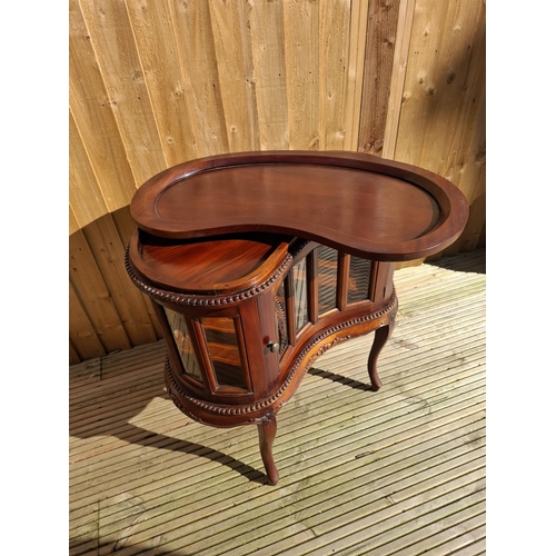 219 - Mahogany kidney bean shaped Drinks cabinet with beveled glass inserts and removable tray.