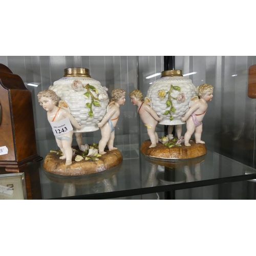 1243 - German Porcelain Cherub Mounted Oil Lamp Bases - approx 16cm tall, 4cm fittings.