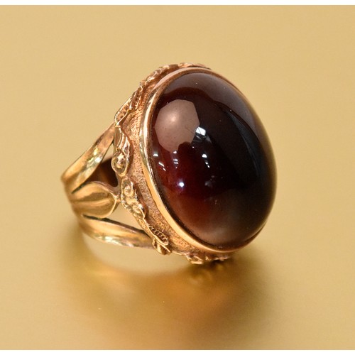 14ct Rose Gold Dark Cherry Amber Cabuchon Dress Ring the mount decorated with a continuous band of Scallop & C-scrolls, weighs 13.1g, size UK K.