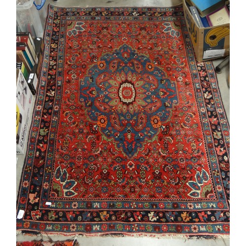 2452 - Antique Persian Design Wool Rug, Central Flowerhead on a red ground, approx 158 x 107cm.