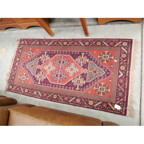 3128 - Geometric Fringed & Bordered Rug  Red Design On Purple Ground ( 134 x 67cm Approx.)