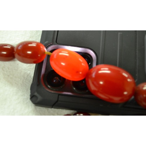 2410 - String of Graduated Cherry Amber Beads, approx 62g, 41cm long, largest bead measuring 3cm across.