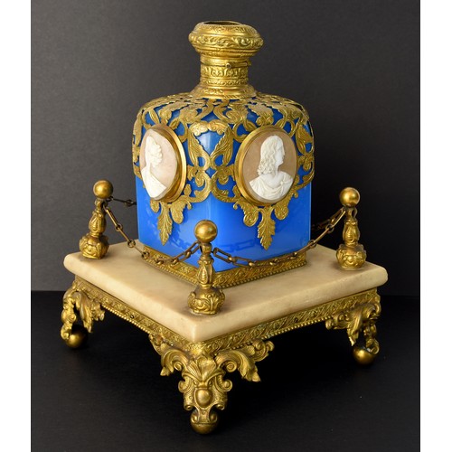 Antique French Perfume Bottle, cameo decorated, blue glass body with gilt brass overlay, standing on square shaped marble base on ornate brass supports, approx 19cm tall.