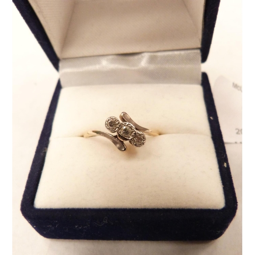 27 - A three stone diamond ring. In gold marked 18. Size L. 1.9g gross