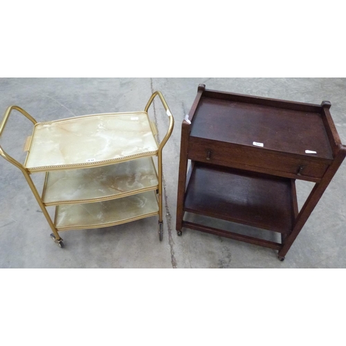 421 - An oak two tier serving trolley with cutlery drawer and another example in gilt metal