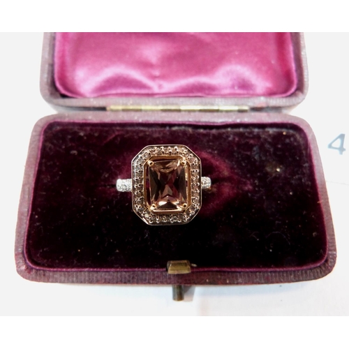 47 - A green step cut tourmaline ring with thirty diamonds and five to each shoulder. In gold marked 375.... 