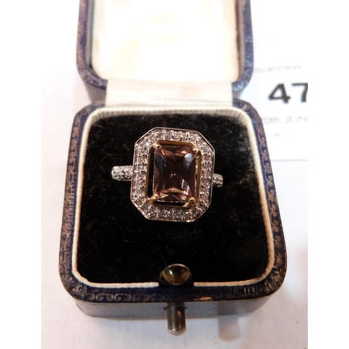 47 - A green step cut tourmaline ring with thirty diamonds and five to each shoulder. In gold marked 375.... 