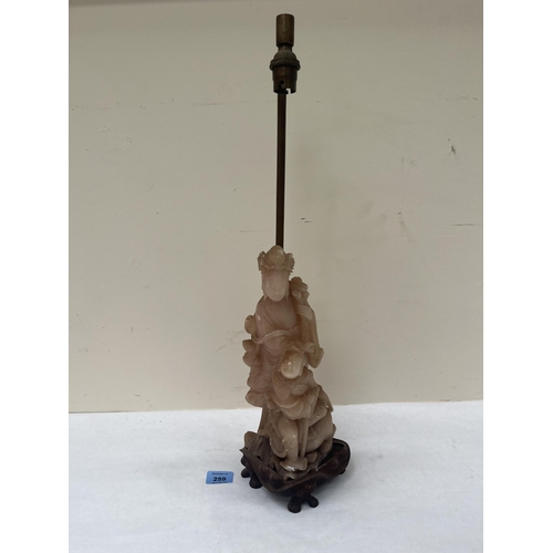 259 - A 1920s soapstone lamp base carved as a figure of Guanyin. The figure and wood base 13½' high. Losse... 