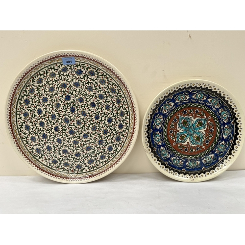 301 - A middle eastern pottery glazed charger. 16' diam and another smaller example