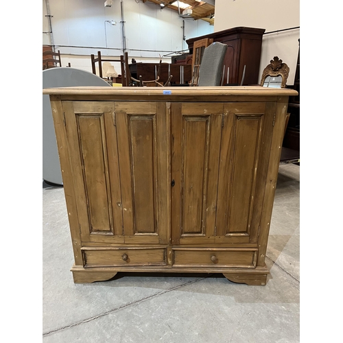 393 - A pine cupboard enclosed by a pair of folding doors over conforming base drawers. 48' w x 47'h