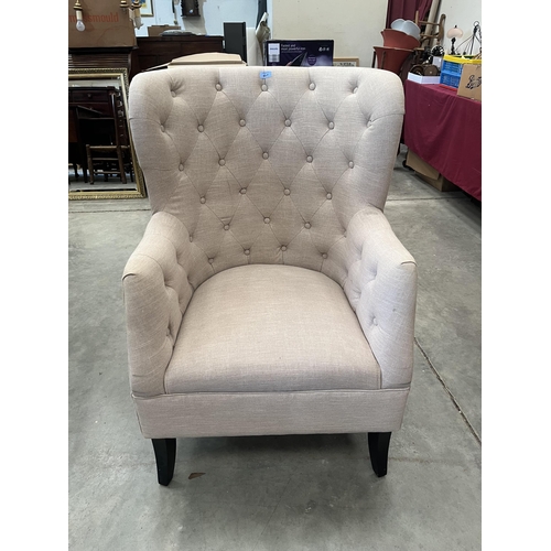 417 - An upholstered armchair with buttoned back