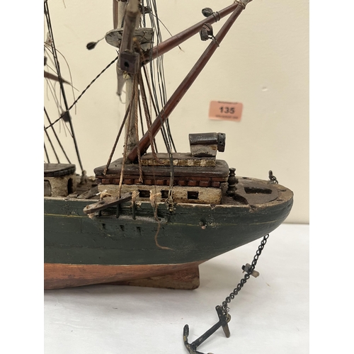 135 - A scratch-built carved wood and painted model of a three masted ship, fully rigged. The hull 21' lon... 