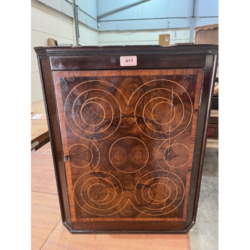 411 - An oyster veneered and line inlaid hanging corner cupboard. 21¾' high