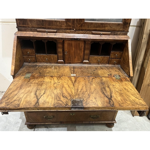 430 - An 18th century walnut bureau bookcase, enclosed by a pair of mirrored doors over a pair of candle s... 