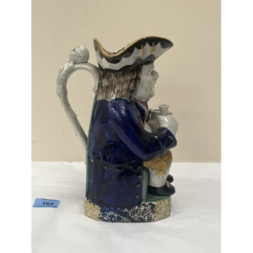 164 - A late 18th century / early 19th century pearlware Toby jug, the character holding a pitcher and gla... 