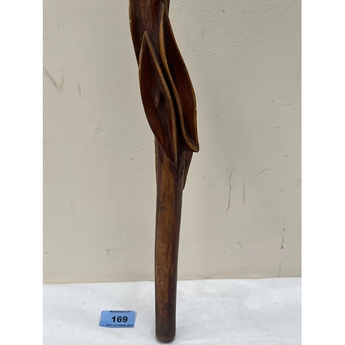 169 - An African treen stick, sinuously carved with a serpent and leafy foliage. 35' long