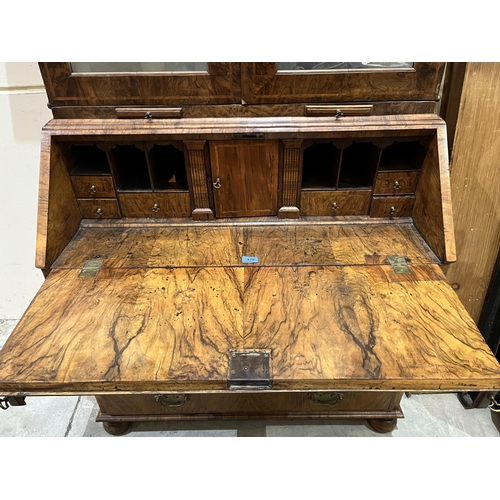 275 - An 18th century walnut bureau bookcase, enclosed by a pair of mirrored doors over a pair of candle s... 