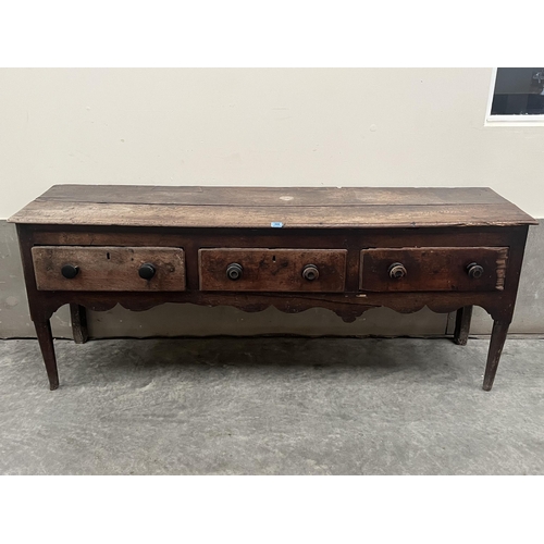 486 - A mid-18th century joined oak low dresser with three drawers over a wavy apron, on turned tapered fo... 