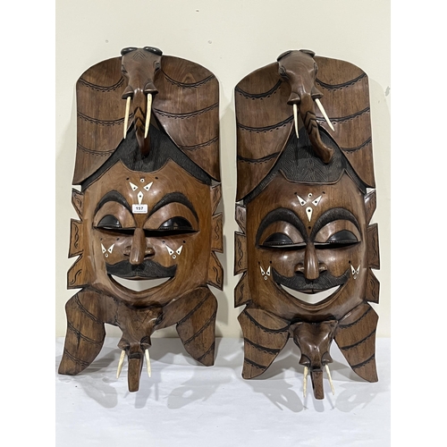 157 - Two similar African carved hardwood masks with bone inlay and tusks. 35' high approx.