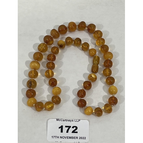 172 - A necklace of clear and clouded amber beads. The string 17' long approx. 20g