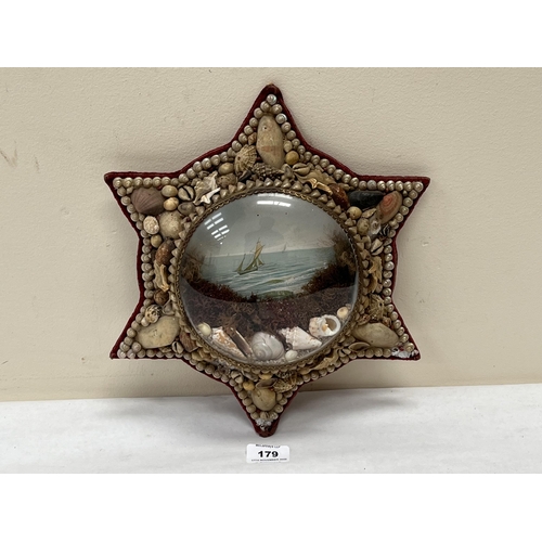 179 - A 19th century sailor's shellwork Valentine, of star form, with shells, seaweed and seascape behind ... 