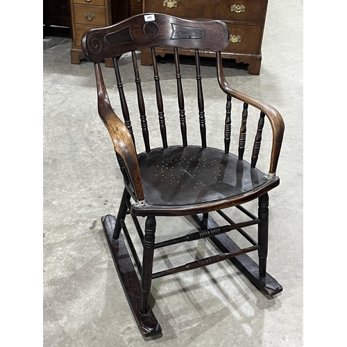 441 - An early 20th century oak spindle - back rocking armchair