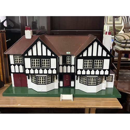 106 - A Tri-Ang mock Tudor two bay doll's house with integral garage. c.1935. Later painted and wired for ... 