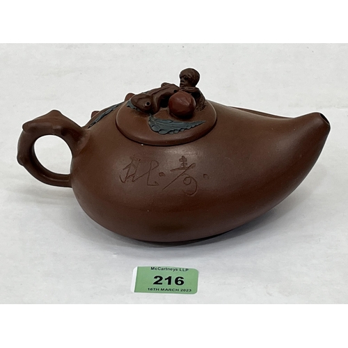 216 - A Chinese Yixing Zisha clay teapot. 7¾' long over handle.  Seal mark to base