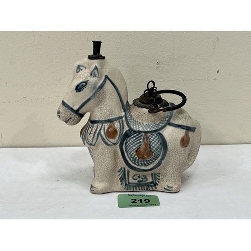 219 - An oriental figure of a horse with metal mounts. 5¾' high