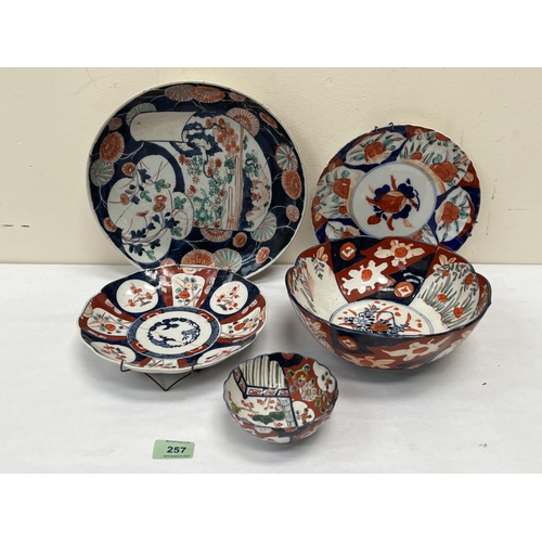 257 - Five items of Japanese Imari ceramics. The larger dish with stapled repairs