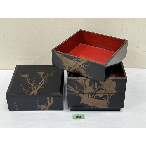 269 - A Japanese black lacquer box in four sections, gilded in low relief with birds and prunus. 7'w x 10¼... 