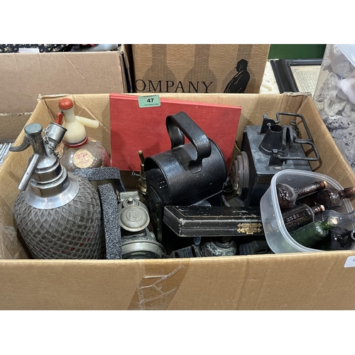 47 - A box of soda syphons, acetylene and other vintage lamps etc.