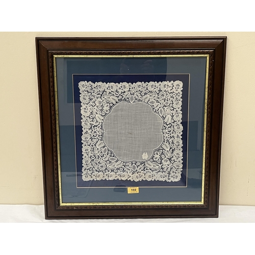 102 - A framed and mounted square of Honiton lace. c.1890. The textile 13¼' x 13¼'