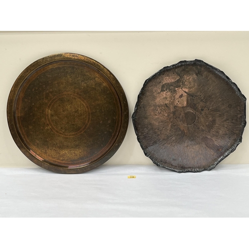 118 - An Arts and Crafts style copper tray with shaped rim, 21½' diam; together with an Islamic brass tray