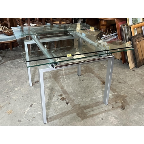 289 - A modernist design glass topped drawleaf table and four chairs