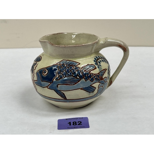 182 - A C.H. Brannam (Barum) glazed pottery jug, sgraffito decorated with fish and reeds. 3¾' high