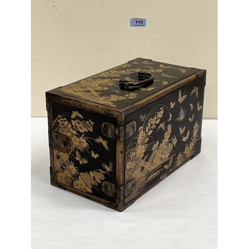 112 - A Japanese black lacquer table chest, the three drawers enclosed by a door, all-over decorated with ... 