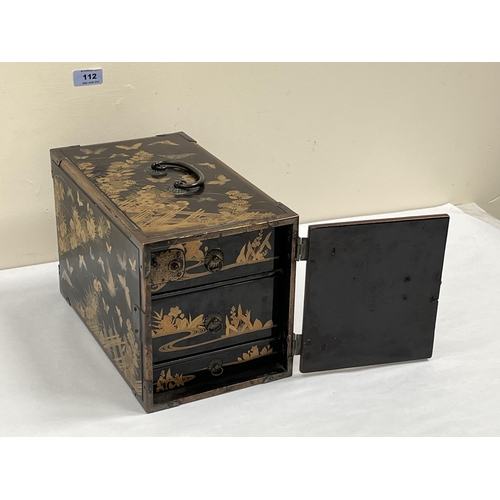 112 - A Japanese black lacquer table chest, the three drawers enclosed by a door, all-over decorated with ... 