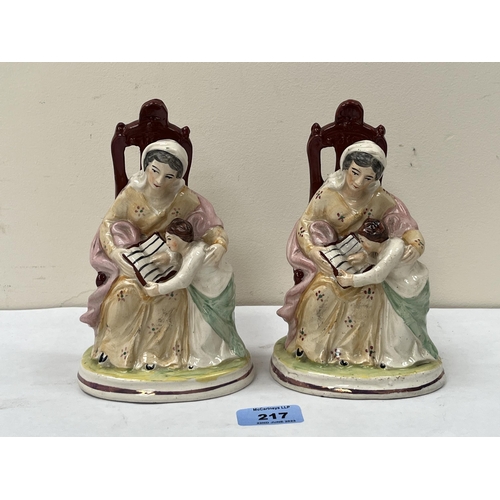 217 - A pair of 19th century Staffordshire groups, seated lady with boy reading a book. 7' high