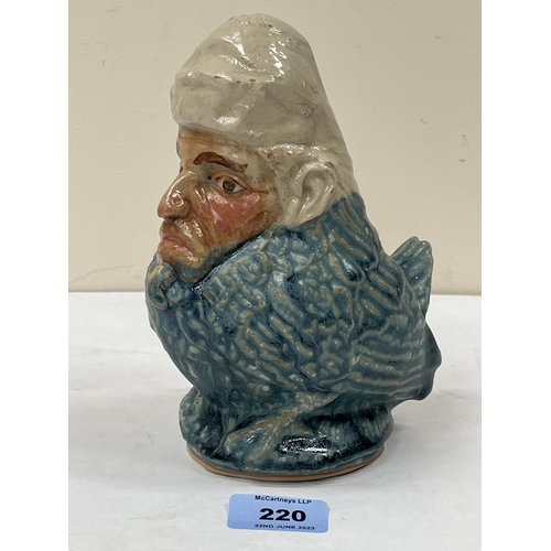 220 - An unusual glazed pottery figure of a bird with human face. 7½' high