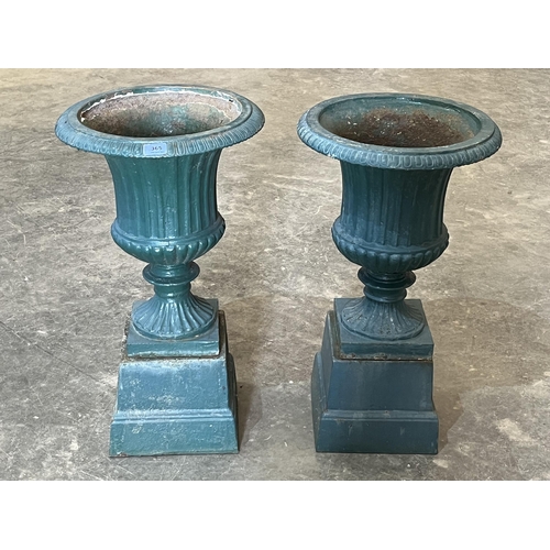 365 - A pair of cast iron campana garden vases on stands. 26½' high