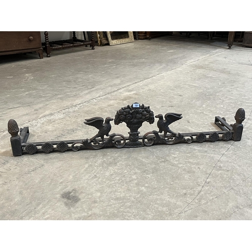 387 - A cast iron fire curb, cast with a basket of fruit and adorsed birds. 56' wide