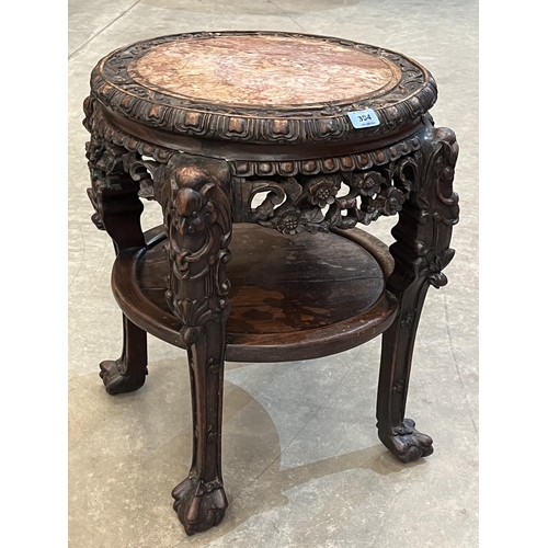 394 - A 19th century carved hardwood pot stand with inset marble, raised on anthropomorphic legs united by... 