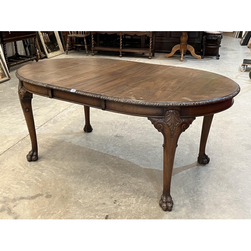 395 - A 1920s mahogany dining table on shell moulded turned tapered legs with hairy paw feet. 70' long wit... 