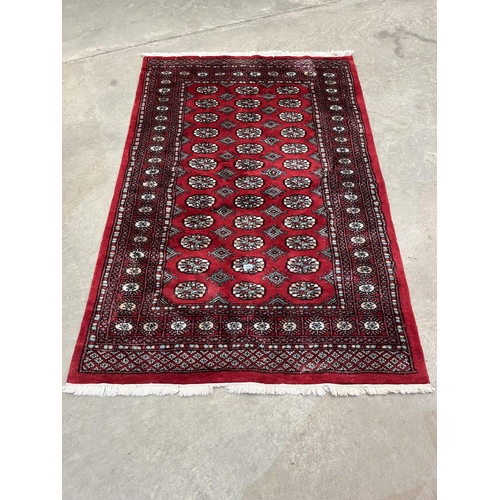 418 - A red ground eastern rug. 76' x 50'