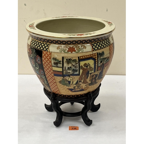 136 - A Japanese fish bowl on wood stand, decorated with figure or foliate scenes in four reserves. 12¼' d... 
