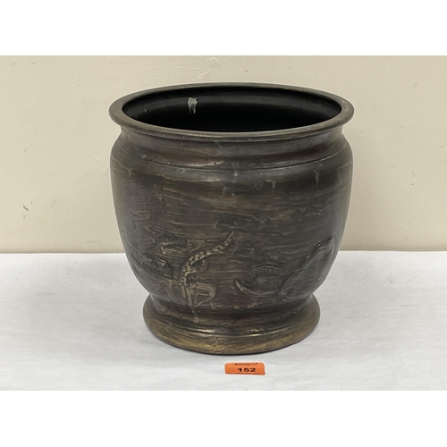 152 - A Japanese brass jardiniere decorated with a continuouse landscape in low relief. 9' high
