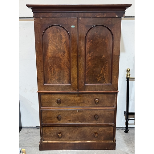 364 - A Victorian mahogany linen press, enclosed by a pair of arch panel doors, retaining three original s... 