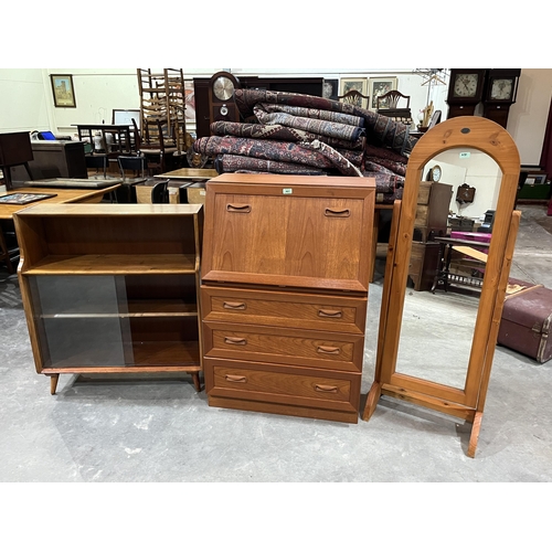 481 - A teak bureau; a pine cheval glass and a glazed bookcase. (3)