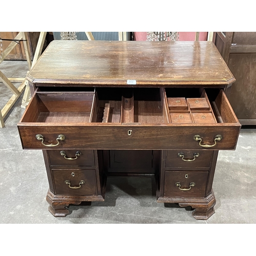 366 - A 19th century mahogany kneehole desk with canted top and reeded corners, the fitted frieze drawer o... 